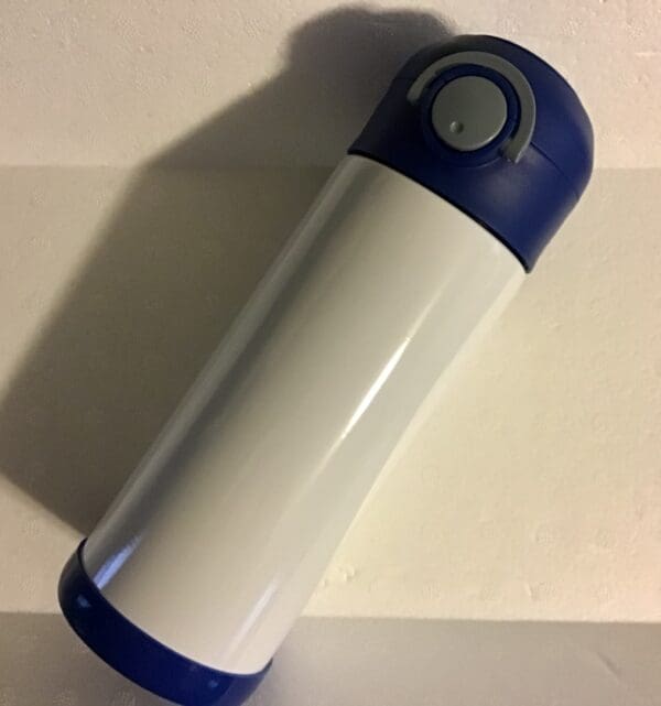 A white and blue thermos sitting on top of a table.