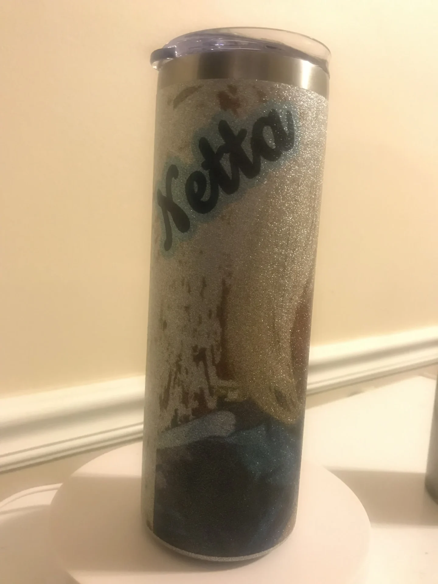 A tall glass with some type of liquid inside