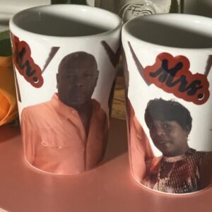 Two personalized mugs with "mr." and "mrs." labels and photos of a couple, flanked by orange roses.