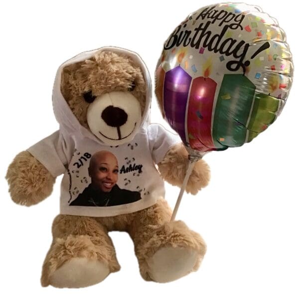 A Teddy Bear Hoodie wearing a white hoodie with an image and text printed on it, holding a colorful 'happy birthday' balloon.